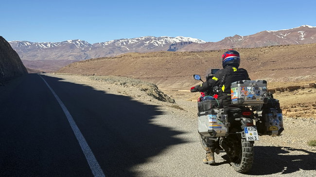 Descente sur une route sinueuse vers une vallée montagneuse isolée