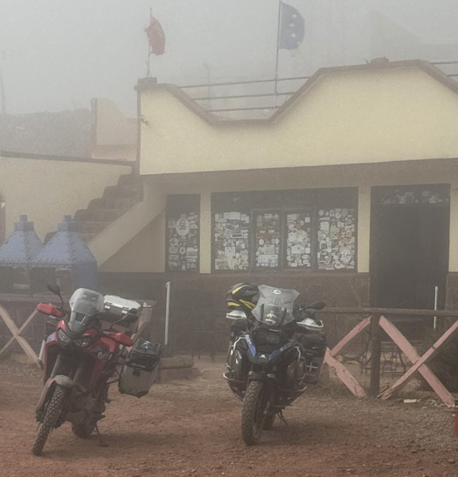 Route de col dans le Haut Atlas, enveloppée d’un épais brouillard et bordée de travaux routiers