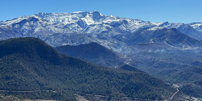 Descente du Haut Atlas sur une large route de montagne asphaltée, à travers un paysage de plus en plus sec et aride