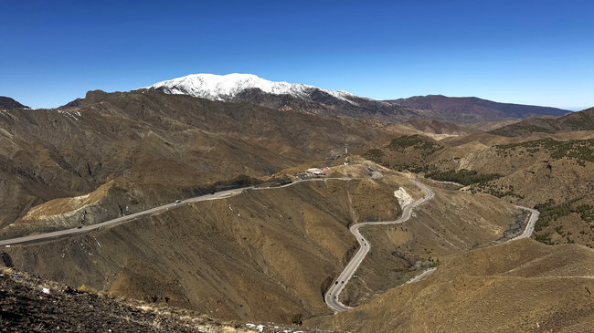 Point de vue au sommet du col du Haut Atlas, avec un vaste panorama sur la route sinueuse et les montagnes