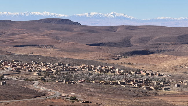 Vue sur la vallée du Drâa, avec des montagnes arides et des zones verdoyantes le long du fleuve